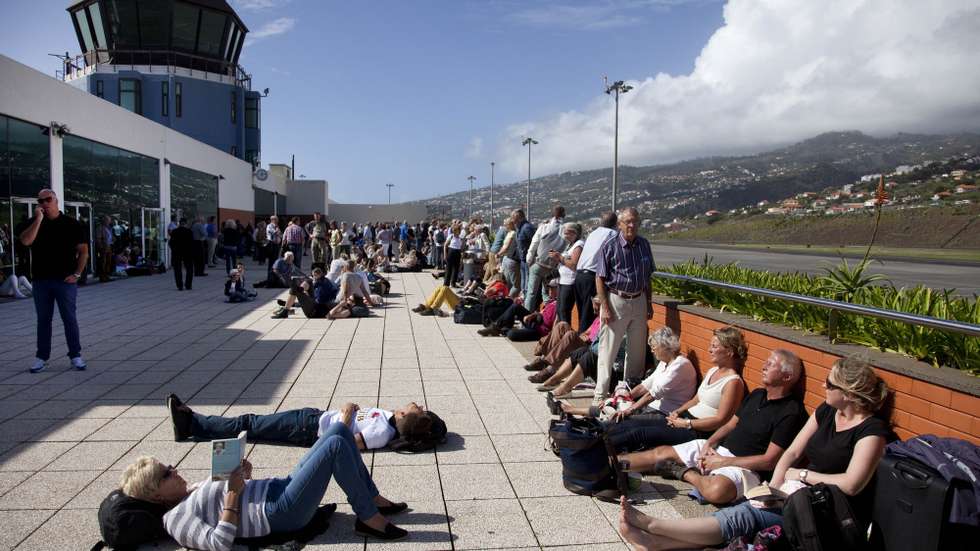 Passageiros aguardam por avião no exterior do aeroporto da Madeira, no Funchal, 20 de outubro de 2014. Os voos têm sido cancelados devido ao vento forte que se faz sentir na Ilha da Madeira deixando centenas de passageiros no aeroporto da Madeira. PAULO CUNHA/LUSA