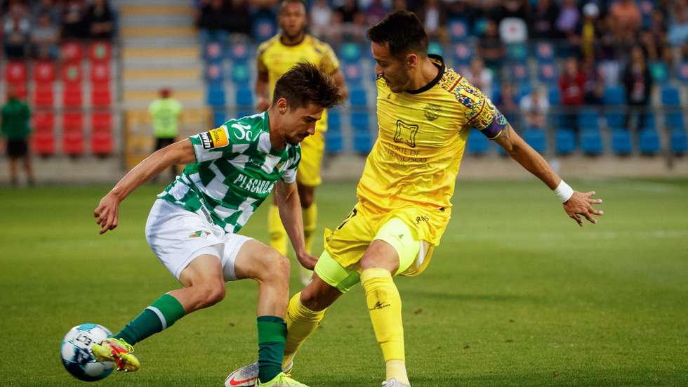 O jogador do GD Chaves João Teixeira (D) disputa a bola com o jogador do Moreirense FC Rodrigo Conceição (E), durante o primeira mão do Play Off de acesso à Primeira Liga 2021/22, entre o GD Chaves e o Moreirense FC, disputado no Estádio Municipal Eng.º Manuel Branco Teixeira, em Chaves, 21 de maio de 2022. PEDRO SARMENTO COSTA/LUSA