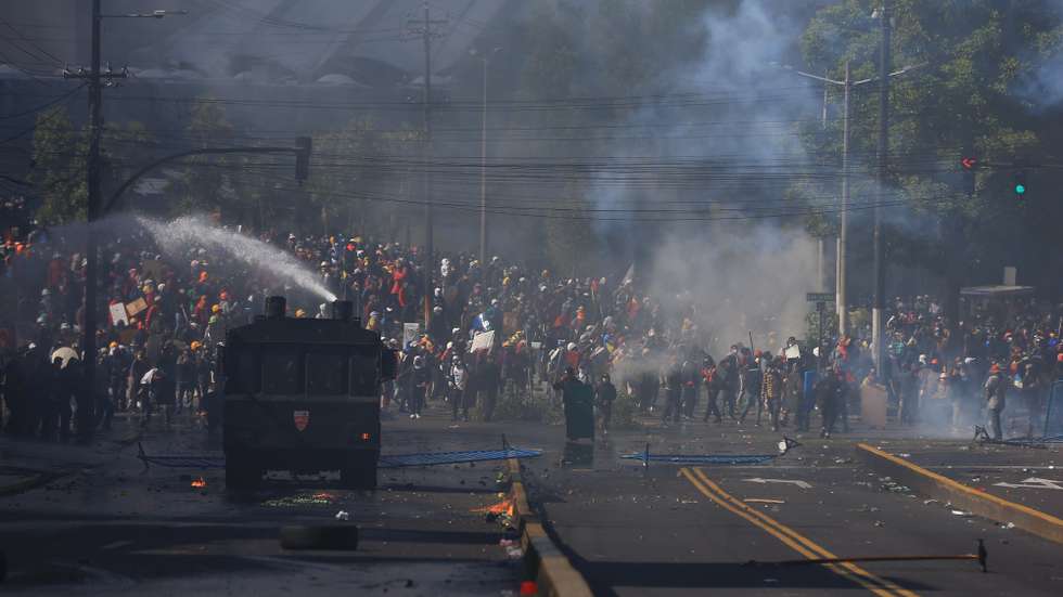 epa10030762 Police disperse protesters trying to reach the National Assembly headquarters in Quito, Ecuador, 23 June 2022. In the demonstrations that began on June 13, the indigenous people ask that the price of gasoline be reduced, that the prices of essential products be controlled, that there be no privatization of state companies, nor a labor flexibility that makes employment precarious and that the debts of the peasants be relieved, among others.  EPA/Jose Jacome