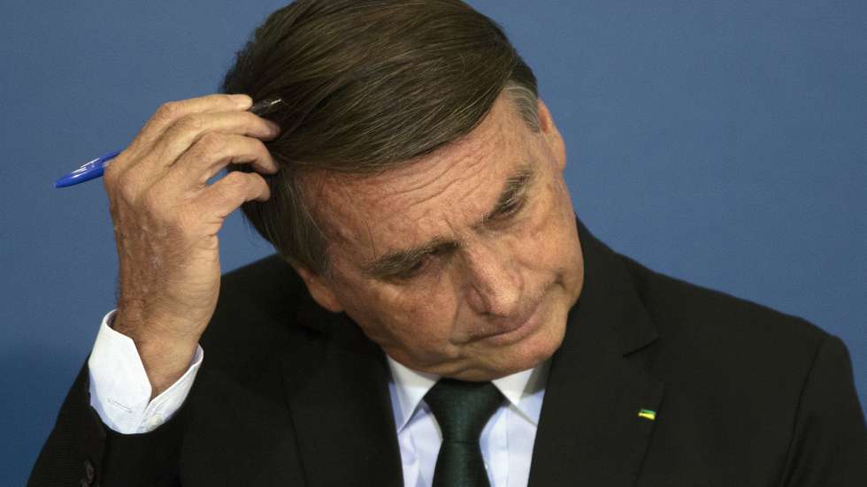 epa10024481 The President of Brazil Jair Bolsonaro, touches his head while participating in an act of National Policy for the Recovery of Learning in Basic Education, and the MECPlace, Innovation Ecosystem, and Digital Educational Solutions, at the Palacio do Planalto, in Brasilia, Brazil, 20 June 2022.  EPA/Joedson Alves