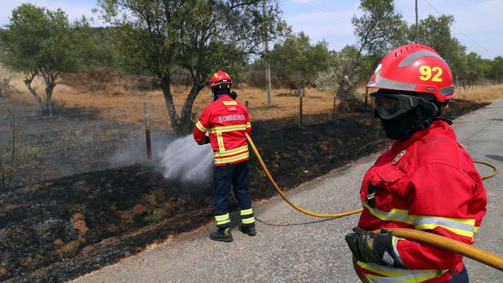 Bombeiros fazem o rescaldo de um incêndio rural que foi rapidamente controlado por populares, bombeiros e uma equipa da Unidade de Emergência de Proteção e Socorro (UEPS) da GNR, na freguesia de Santiago do Escoural, Montemor-o-Novo, 11 de julho de 2022. NUNO VEIGA/LUSA