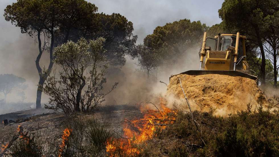 Máquinas de rasto durante o combate ao incêndio que lavra na zona da Quinta do Lago, em Almancil, Faro, 13 de julho de 2022. Dezasseis dos 18 distritos de Portugal continental estão hoje sob aviso vermelho, o mais grave, devido ao tempo quente, com mais de uma centena de concelhos em perigo máximo de incêndio rural. DUARTE DRAGO/LUSA