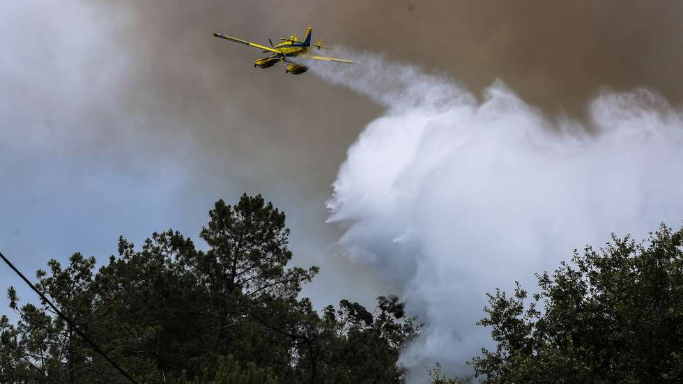 Um avião faz uma descarga de água junto à aldeia de Rebolo, durante o incêndio que começou em Abiul, Pombal, na passada sexta-feira, Rebolo, Ansião, 14 de julho de 2022. PAULO NOVAIS/LUSA
