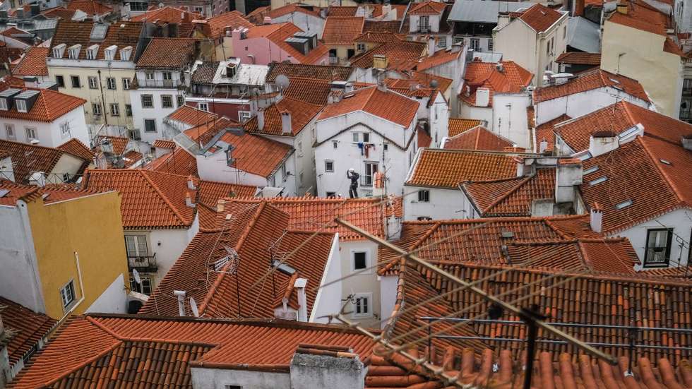 epa09282366 A man works on a roof at Bairro de Alfama in Lisbon, Portugal, 18 June 2021. TheÂ Portuguese cabinetÂ announced on 17 June the ban on circulation to and from the Lisbon Metropolitan Area (AML) on weekends, starting at 15:00 on 18 June, due to the rise in cases ofÂ Covid-19 in this territory.  EPA/MARIO CRUZ