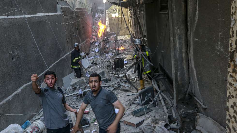 epa10107370 Palestinians inspect a destroyed building after Israeli airstrikes in Gaza City, 05 August 2022. According to the Palestinian ministry of health, at least four people were killed, including a child, in a series of Israeli airstrikes on multiple targets in the Gaza Strip including a residential apartment in neighborhood of Al-Rimal. Al-Quds Brigades, the armed wing of the Palestinian Islamic Jihad, announced that senior leader Tayseer al-Jabari was killed in the attacks.  EPA/MOHAMMED SABER