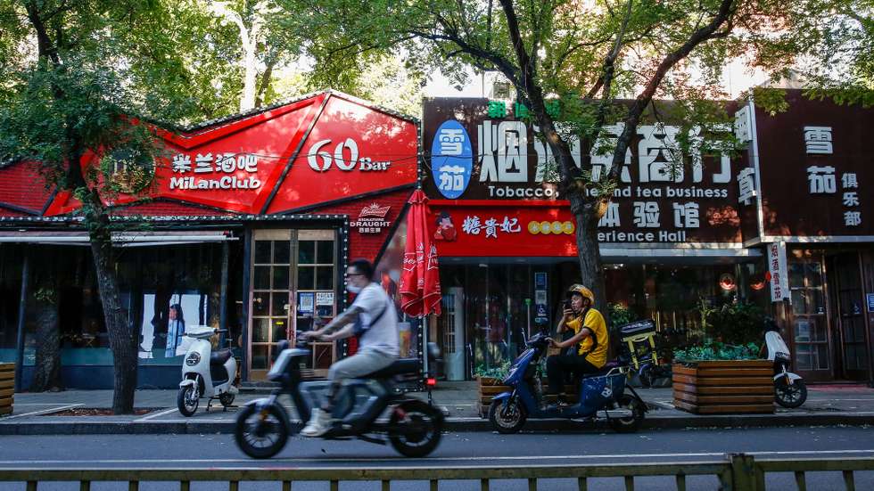 epa10133361 A man rides an electric bicycle past closed bars in Beijing, China, 22 August 2022. China has cut its benchmark loan rates to help revive its economy. China's one year loan prime rate was cut from 3.7 percent to 3.65 percent, while the loan rates for mortgages were cut from 4.45 percent to 4.3 percent, the People's Bank of China (PBOC) said.  EPA/MARK R. CRISTINO
