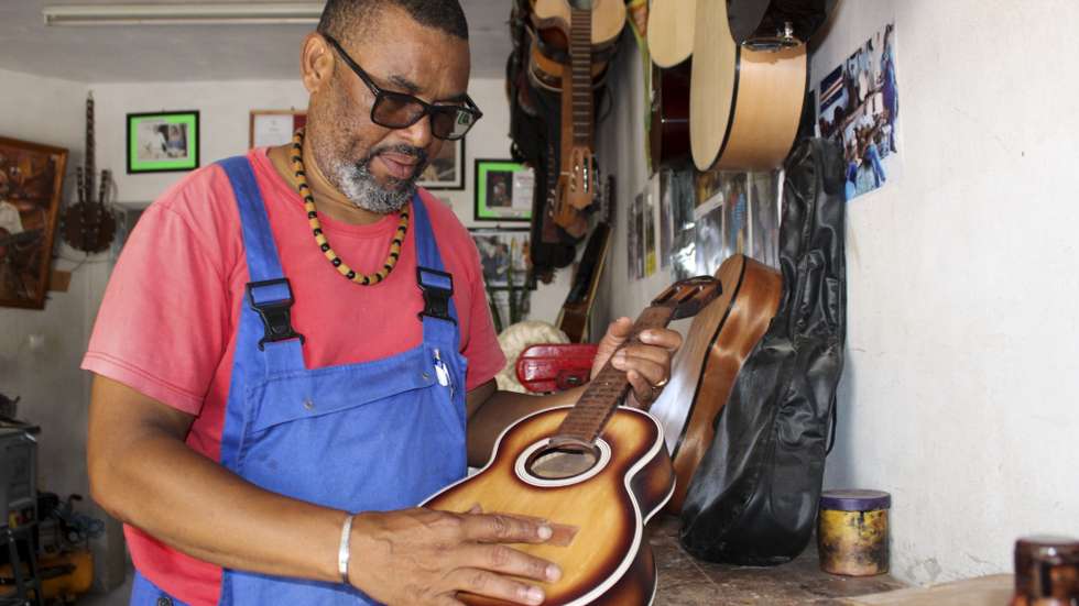 Aniceto Gomes, posa para a fotografia no seu atelier onde começou há 24 anos, a confeção de instrumentos musicais de corda (viola, violão e cavaquinho), no bairro de Monte Sossego, mas a história na confeção de instrumentos musicais remonta 16 anos antes, na escola do mestre Baptista, que reunia outros jovens para aprender esta arte, no Mindelo, ilha de São Vicente, Cabo Verde, 14 de setembro de 2022. Aniceto Gomes começou a aprender a construir instrumentos musicais de corda com 16 anos, no atelier do mestre Baptista, e nunca mais parou, tornando-se num dos principais artesões cabo-verdianos, mas, humildemente, diz que não sabe tocar. (ACOMPANHA TEXTO DA LUSA DO DIA 19 DE SETEMBRO DE 2022). SIDNEY NEWTON/LUSA