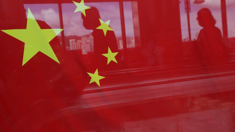 epa10040194 People are reflected in a window decorated with a People’s Republic of China flag in Hong Kong, China, 24 June 2022 (issued 29 June 2022). On 01 July 2022 the city will mark the 25th anniversary of the former British colony's return to Chinese rule and the establishment of the Hong Kong Special Administrative Region of the People's Republic of China (Hong Kong SAR or HKSAR) as well as the inauguration of a new Chief Executive.  EPA/JEROME FAVRE  ATTENTION: This Image is part of a PHOTO SET