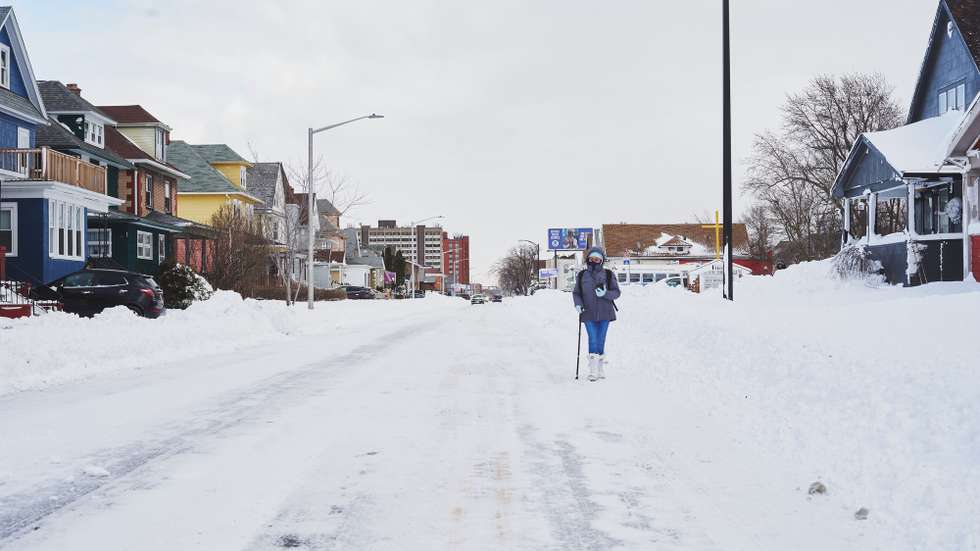 epa10378184 A woman walks along Kenmore Avenue as the effects of a massive winter storm which has affected large portions of the United States, continues in Buffalo, New York, USA, 25 December 2022. Much of the United States is currently experiencing some sort of winter weather as a result of the large storm which was generated by a bomb cyclone, the meteorological phenomenon when the atmospheric pressure quickly drops in a strong storm  EPA/JOSH THERMIDOR