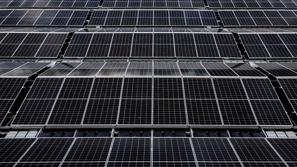 epa10094440 An aerial photo taken with a drone shows solar panels on Germany's biggest floating photovoltaic plant on lake Silbersee in Haltern, Germany, 27 July 2022. More than 5,000 photovoltaic modules produce around 3 million kilowatt hours of electricity per year, saving 1,100 tons of CO2 to fight climate change with renewable power instead of oil, gas and coal.  EPA/SASCHA STEINBACH