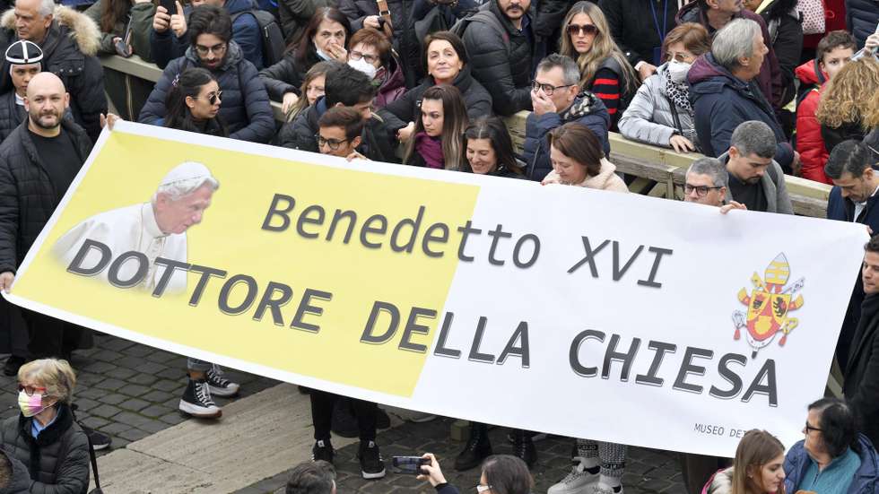 epa10392270 A handout picture provided by the Vatican Media shows faithfuls holding a banner reading 'Benedict XVI - Doctor of the Church' in Saint Peter's Square as Pope Francis leads his Angelus prayer, in Vatican City, 06 January 2023. Pope Emeritus Benedict XVI died on 31 December 2022 at his Vatican residence, at the age 95. His funeral took place on 05 January.  EPA/VATICAN MEDIA HANDOUT  HANDOUT EDITORIAL USE ONLY/NO SALES