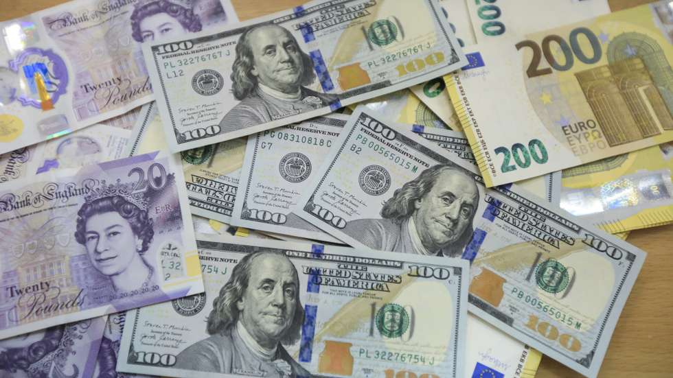 epa10210338 UK Pound sterling, US dollars and Euro banknotes are displayed on a table at a money exchange company in Nairobi, Kenya, 27 September 2022. A worker points at the Euro currency exchange rate against the Kenyan shilling on a currency board at a money exchange company in Nairobi, Kenya, 27 September 2022.  EPA/Daniel Irungu