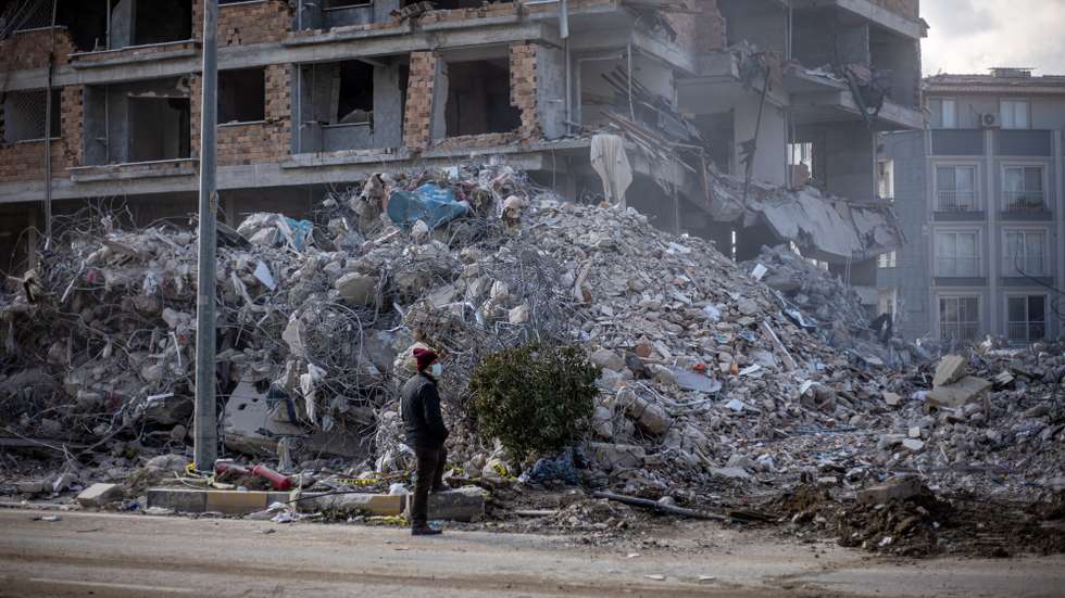epa10478187 A man looks at debris of collapsed buildings after a powerful earthquake, in Hatay, Turkey, 19 February 2023. More than 46,000 people have died and thousands more are injured after two major earthquakes struck southern Turkey and northern Syria on 06 February. Authorities fear the death toll will keep climbing as rescuers look for survivors across the region.  EPA/MARTIN DIVISEK