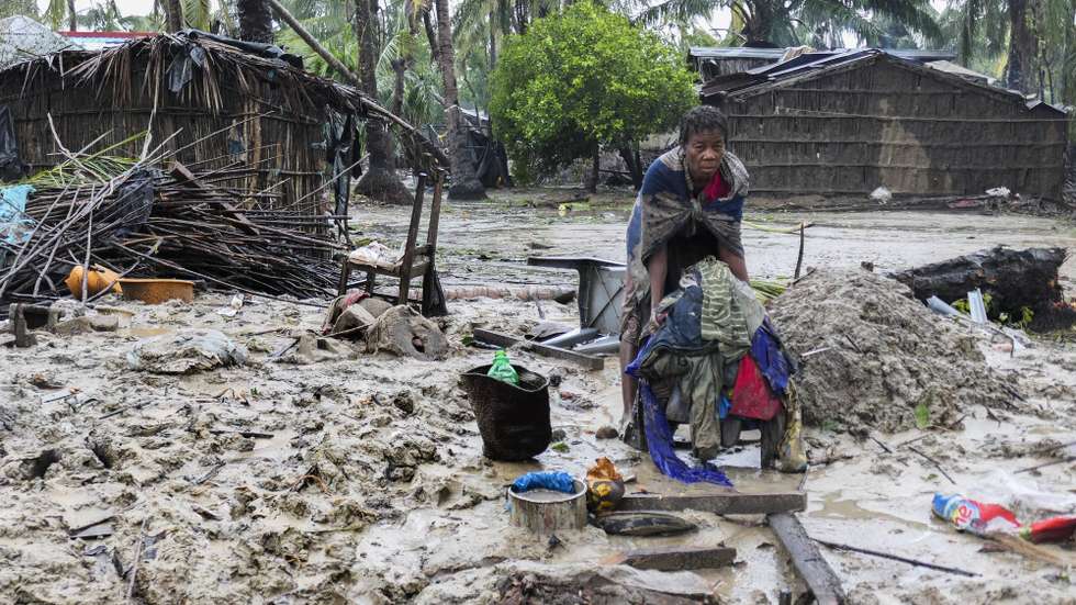 epaselect epa10521047 A woman recovers some clothes after the destruction caused by the storm Freddy in Quelimane, Mozambique, 13 March 2023. This is one of the longest lasting storms ever, after it formed at the beginning of February in the Asian seas, crossing the entire Indian Ocean to the east African coast.  EPA/ANDRÉ CATUEIRA