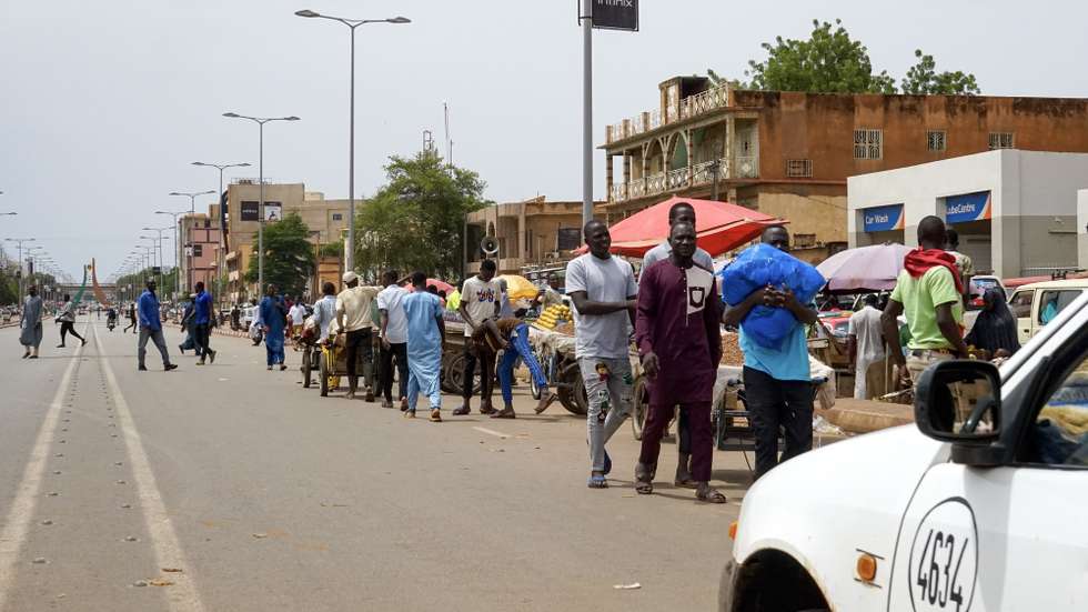 epa10779851 People walk along a main road in Niamey, Niger, 01 August 2023. General Abdourahamane Tchiani, head of the Presidential Guard, declared himself the new leader of Niger after a coup against democratically elected President Mohamed Bazoum on 26 July.  EPA/ISSIFOU DJIBO