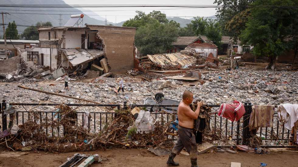 epaselect epa10783998 Mr. Sun recovers belongings from his house following strong rains and floods in the mountains of Mentougou District, west of Beijing, China, 04 August 2023. Beijing recorded its heaviest rainfall in 140 years brought by Typhoon Doksuri, causing floods, the evacuation of thousands of people and 21 deaths.  EPA/MARK R. CRISTINO
