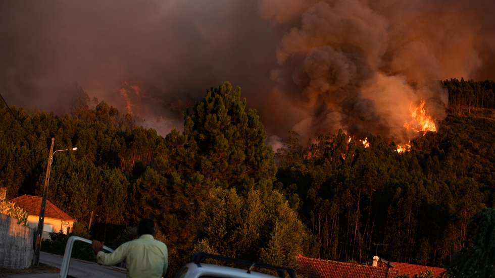 People watch the flames consuming the trees during a forest fire at Matas de Espite, Ourem, Portugal, 6th August 2023. PAULO CUNHA/LUSA