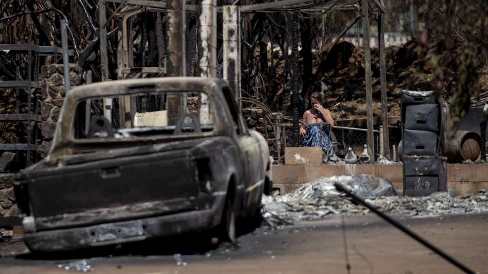 epa10802267 A resident reacts as she walks through the ruins of a a house destroyed by the Lahaina Fire, in Lahaina, Hawaii, USA, 15 August 2023. At least 99 people were killed in the Lahaina wildfire that burned through areas of Maui, which is considered the largest natural disaster in Hawaii's state history.  EPA/ETIENNE LAURENT