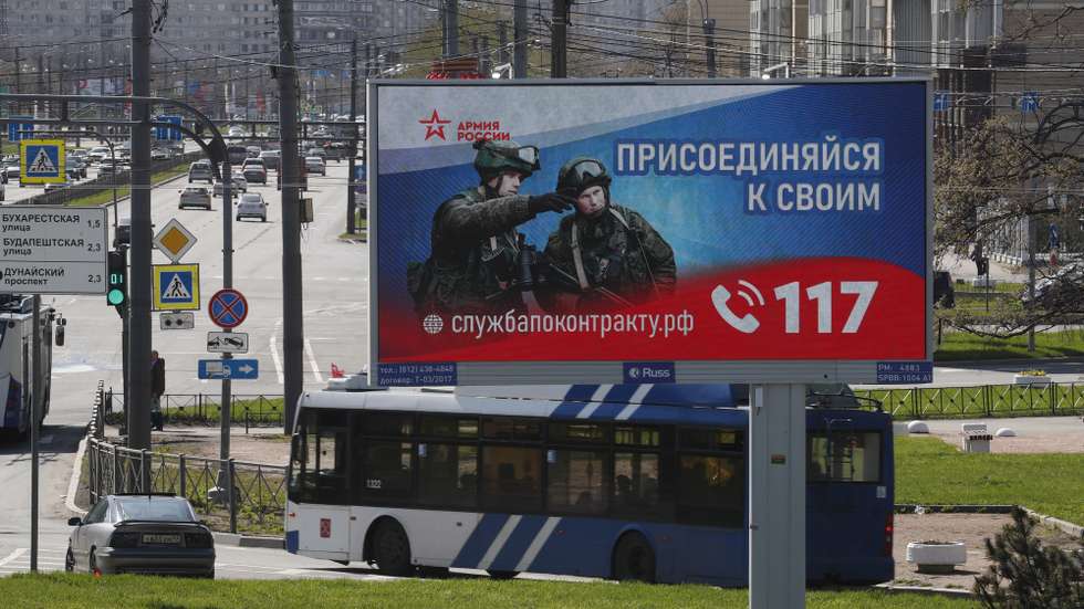 epa10602214 A digital billboard shows Russian soldiers with a slogan reading 'Join your comrades. Contract service' in St. Petersburg, Russia, 01 May 2023. On 24 February 2022 Russian troops entered Ukrainian territory in what the Russian president declared as a 'Special Military Operation', starting an armed conflict.  EPA/ANATOLY MALTSEV