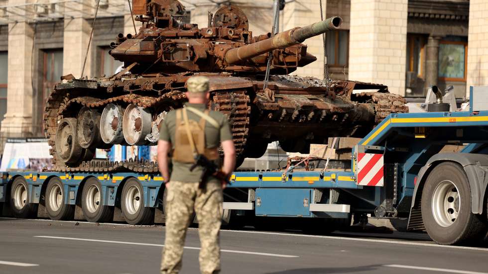 epa10815081 A soldier looks on as Russian armored military vehicles that were seized by the Ukrainian army amid the Russian invasion are put in place along Khreshchatyk Street in Kyiv (Kiev), Ukraine, 23 August 2023. The damaged Russian military machinery was set up in downtown Kyiv prior to the upcoming Independence Day celebrations on 24 August.  EPA/CATHAL MCNAUGHTON
