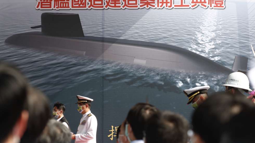epa08838351 A navy officer stands next to a tarpaulin with a computer generated photo of a submarine during the groundbreaking construction ceremony on Taiwan’s first indigenous submarine at a shipyard in Kaohsiung, Taiwan, 24 November 2020. The 1.72-billion US dollar submarine is expected to be completed during the third quarter of 2024 and will be on sea trials scheduled for 2025. Taiwan is currently operating two submarines manufactured by the Netherlands in the late 1980s.  EPA/RITCHIE B. TONGO