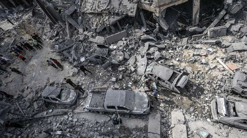epa10909357 Palestinians inspect damaged cars, amid the rubble of a destroyed area, after Israeli air strikes in Gaza City, 09 October 2023. The Israeli army announced on 09 October, it carried out over 500 strikes on targets across the Gaza Strip overnight. Palestinian officials said almost 500 people were killed and over 2,700 were injured after Israel launched retaliatory raids and air strikes. An unprecedented attack on southern Israel on 07 October claimed by the Islamist movement Hamas killed more than 700 Israelis and left over 2,150 injured, the Israeli army said.  EPA/MOHAMMED SABER