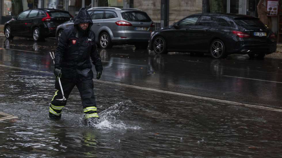 Um bombeiro sapador desentope sarjetas numa área inundada na zona de Benfica em Lisboa, 30 de novembro de 2023. O Instituto Português do Mar e da Atmosfera (IPMA) elevou hoje para laranja o aviso nos distritos de Lisboa, Setúbal e Santarém devido à previsão de períodos de chuva, por vezes forte e persistente. TIAGO PETINGA/LUSA