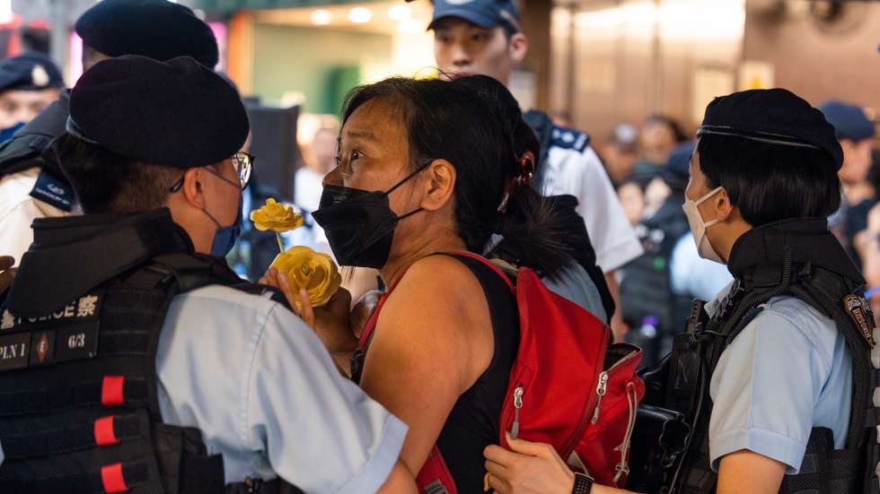 epa10672578 Police argue with pro-democracy activist Chan Po-ying (C), wife of Leung Kwok-hung, better known 'Long Hair', when stopping and searching her in a shopping area near Victoria Park in Hong Kong, China, 04 June 2023. The annual candlelight vigil in Victoria Park is cancelled for the fourth year in a row since 2020 as part of the park is being closed for renovation and pro-Beijing organisations will host a carnival on the grounds instead. Hong Kong was the only city on Chinese soil to publicly hold mass memorials in the past three decades to commemorate the 1989 Beijing Tiananmen Square crackdown but police banned the vigils in 2020 and 2021 citing COVID-19 pandemic health concerns and closed down parts of the Victoria park last year due to security concerns.  EPA/BERTHA WANG