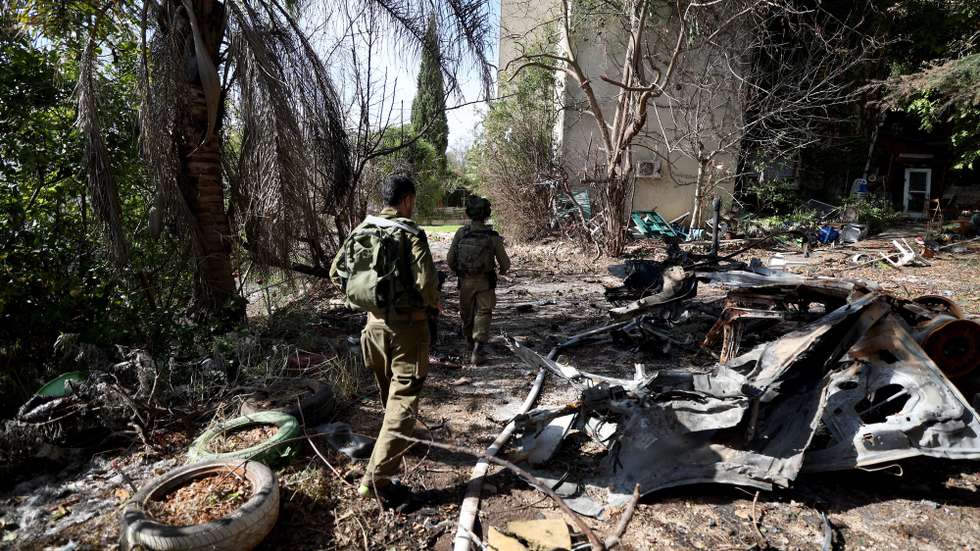 epa11003325 Members of an armed first response group pass a destroyed vehicle at Kibbutz Manara on the Israeli-Lebanon border, 30 November 2023. The Israeli army reports that following the sounding of sirens in the areas of northern Israel, the Aerial Defense Array successfully intercepted a suspicious aerial target that crossed from Lebanon into Israeli territory.  EPA/ATEF SAFADI