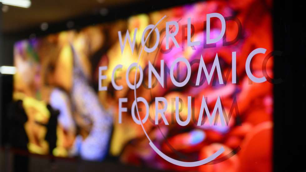 epa11077126 The logo of the WEF on a window of the Congress Center as participants and artificial intelligence generated artwork by Turkish-American media artist Refik Anadol are reflected inside the congress centre on the eve of the 54th annual meeting of the World Economic Forum (WEF) in Davos, Switzerland, 14 January 2024. The meeting brings together entrepreneurs, scientists, corporate and political leaders in Davos under the topic 'Rebuilding Trust' from 15 to 19 January.  EPA/LAURENT GILLIERON