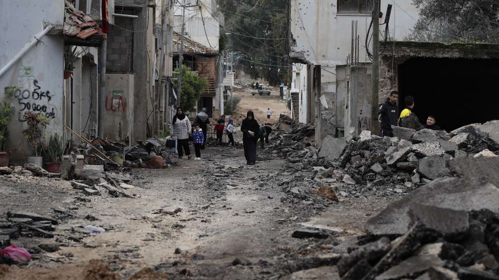 epa11103738 Palestinians walk along a damaged street at the Jenin refugee camp following an overnight Israeli raid in the West Bank city of Jenin, 25 January 2024. More than 25,700 Palestinians and at least 1,330 Israelis have been killed, according to the Palestinian Health Ministry and the Israel Defense Forces (IDF), since Hamas militants launched an attack against Israel from the Gaza Strip on 07 October 2023, and the Israeli operations in Gaza and the West Bank which followed it.  EPA/ALAA BADARNEH