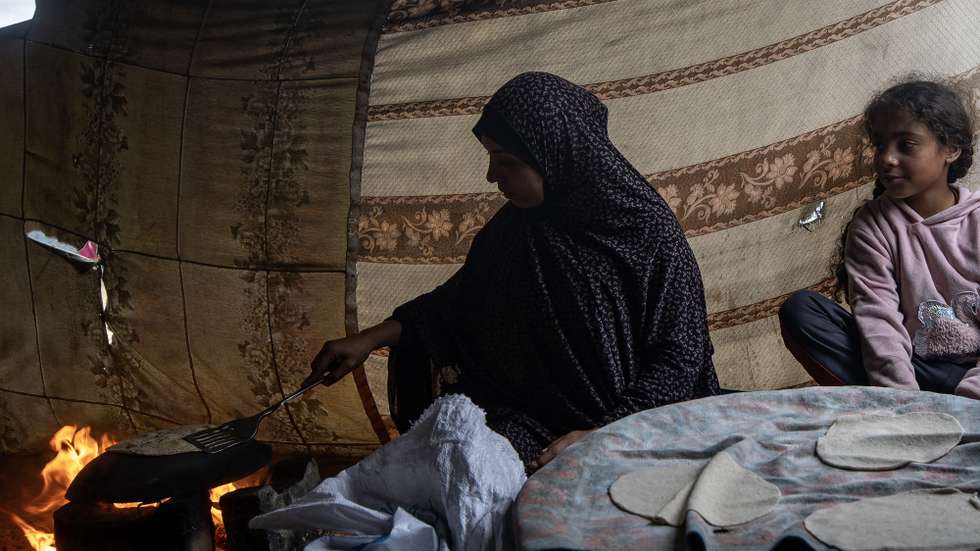 epa11163572 A Palestinian family makes bread in their tent in the Rafah camp, southern Gaza Strip, 18 February 2024. Since 07 October 2023, up to 1.9 million people, or more than 85 percent of the population, have been displaced throughout the Gaza Strip, some more than once, according to the United Nations Relief and Works Agency for Palestine Refugees in the Near East (UNRWA), which added that most civilians in Gaza are in 'desperate need of humanitarian assistance and protection'.  EPA/HAITHAM IMAD
