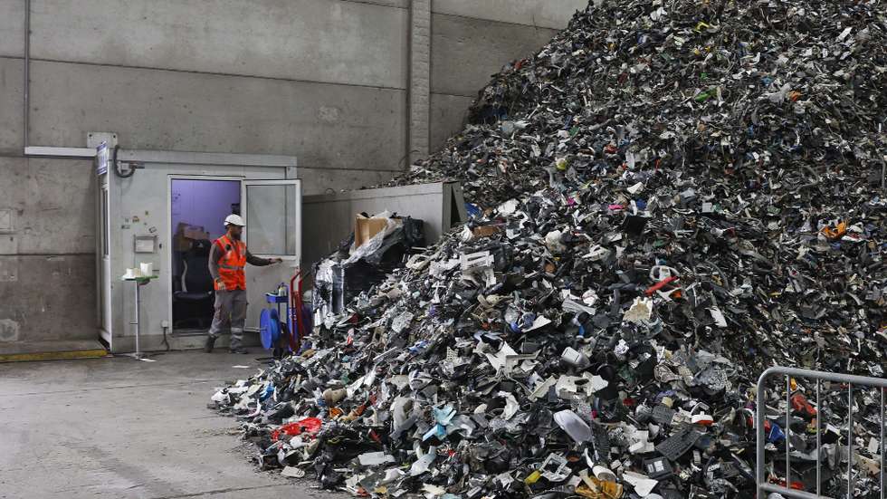 Um funcionário da Veolia observa um monte de equipamentos elétricos, especialmente pequenos aparelhos em fim de vida, no Centro Operacional de Resíduos da empresa em Santo Antão do Tojal, Loures, 27 de outubro de 2023. O Eletrão promove um conjunto de visitas para mostrar o que acontece aos resíduos depois de serem entregues para reciclagem, sejam embalagens, pilhas ou equipamentos eléctricos usados. ANTÓNIO PEDRO SANTOS/LUSA