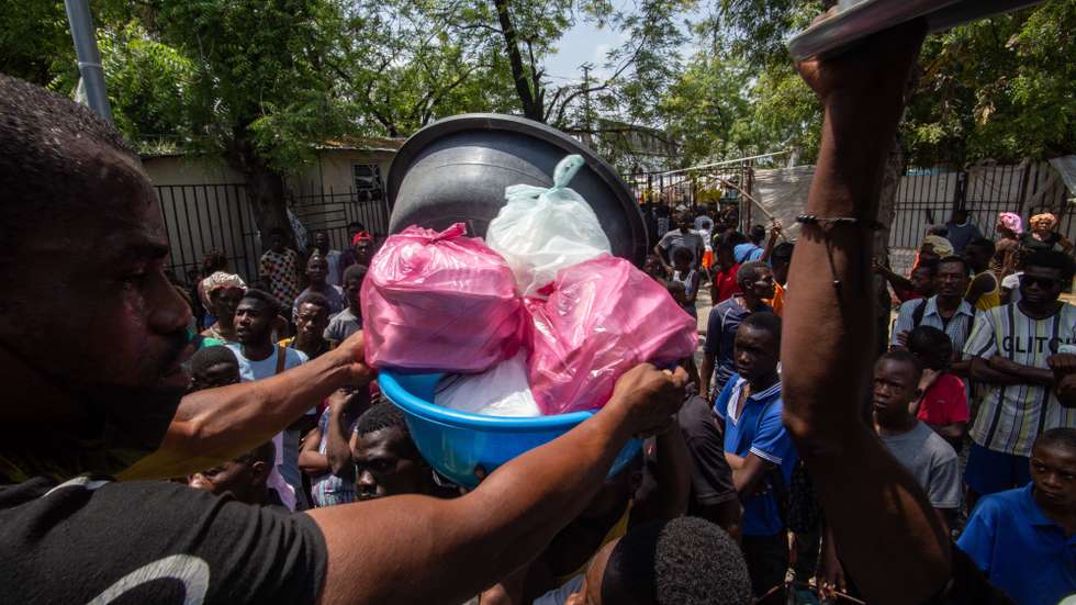 epa11234709 Haitian citizens try to get goods at Liceo Marie Jeanne shelter in Port-au-Prince, Haiti, 21 March 2024. The health and humanitarian situation in the Haitian capital, Port-au-Prince, is worsening due to the closure of its airport and the difficulty of access to the seaport, whose surroundings are controlled by armed gangs, warned the World Health Organization (WHO).  EPA/Mentor David Lorens