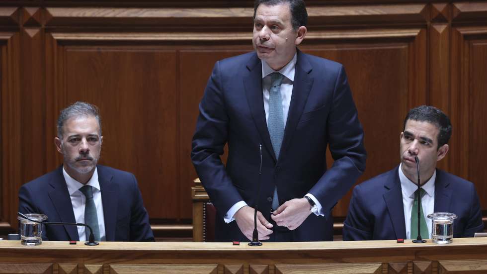 O primeiro-ministro, Luís Montenegro (C), ladeado por Pedro Duarte (E), ministro dos Assuntos Parlamentares, e por António Leitão Amaro, ministro da Presidência, intervém durante o debate parlamentar, na Assembleia da República, em Lisboa, 26 de junho de 2024. ANTÓNIO COTRIM/LUSA