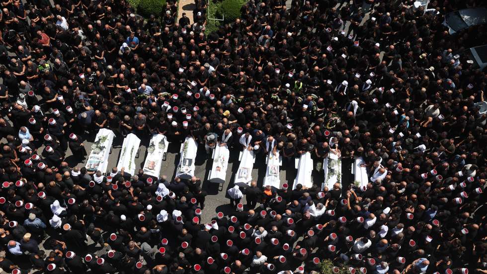 epa11501556 People attend the funeral of ten young people killed by a rocket attack from Lebanon, in the village of Majdal Shams in the annexed Golan Heights, 28 July 2024. According to the Israel Defense Forces (IDF), a rocket launched from Lebanon toward Majdal Shams caused multiple civilian casualties, including children. Approximately 30 projectiles were identified as crossing from Lebanon, the IDF said.  EPA/ATEF SAFADI
