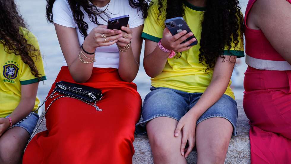 Duas jovens consultam o telemóvel, em Lisboa, 07 de agosto de 2024. Adolescência. Comunicações. Internet. ANTÓNIO PEDRO SANTOS/LUSA