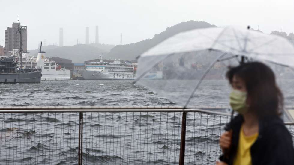 epa11493719 A woman walks in a harbour as Typhoon Gaemi is set to make landfall, in Keelung, Taiwan, 24 July 2024. After having hovered in the waters of the Philippines, Typhoon Gaemi is expected to make landfall in Taiwan on the evening of 24 July, with the Taiwanese weather agency issuing sea and land warnings. People are also reminded to monitor changes to international and domestic flights as disruptions may occur due to the tropical storm that brings in heavy rain and powerful winds.  EPA/DANIEL CENG