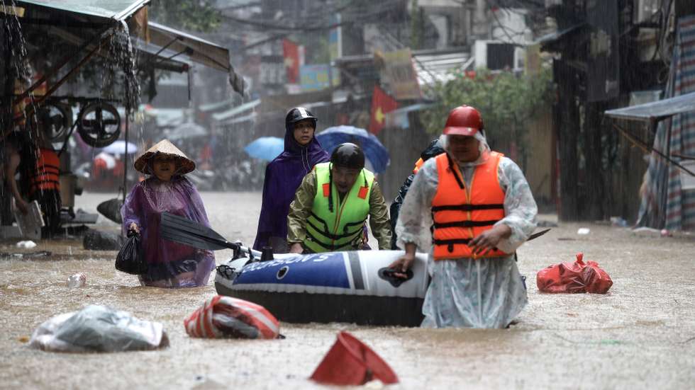 epa11598423 People push an inflatable boat through the flood waters in a street of Hanoi, Vietnam, 11 September 2024. Typhoon Yagi, which struck northern Vietnam over the weekend, triggered severe flooding in Hanoi. The Red River&#039;s rapid rise inundated communities along the riverbank, forcing residents to seek refuge in safer areas. As of 11 September, the Vietnam Disaster and Dyke Management Authority reported at least 152 fatalities and 140 missing persons due to the typhoon.  EPA/LUONG THAI LINH