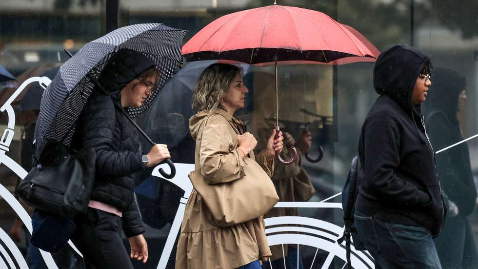Pessoas abrigam-se da chuva junto ao Hospital São João, no Porto, 24 de setembro de 2024. De acordo com o Instituto Português do Mar e da Atmosfera (IPMA), prevê-se a ocorrência de períodos de chuva persistente a partir de hoje nas regiões Norte e Centro e que será por vezes forte na quarta e quinta-feira. ESTELA SILVA/LUSA