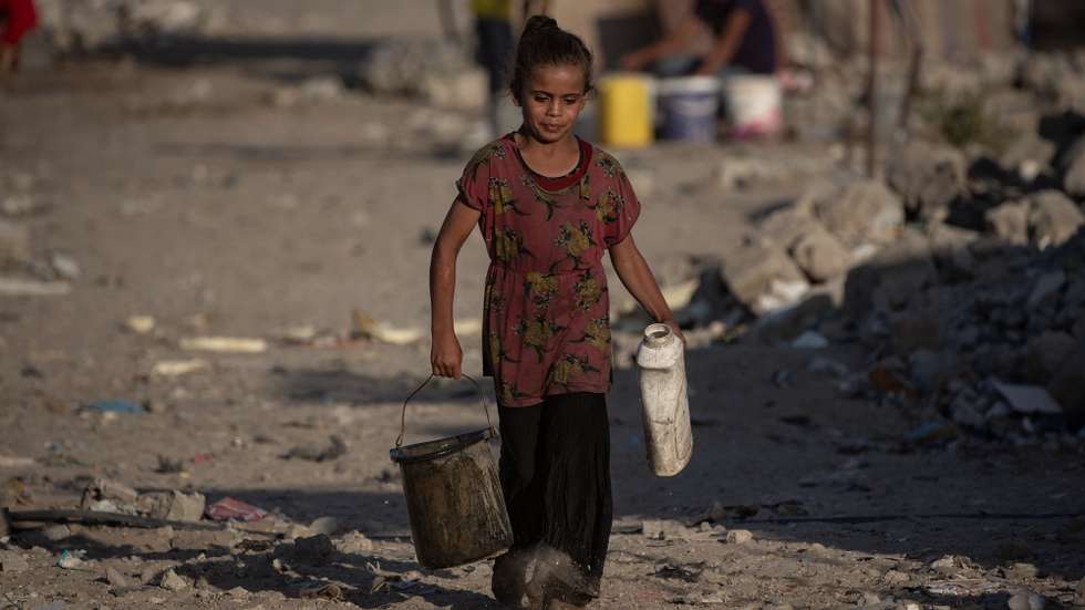 epa11523227 A young Palestinian girl carries water at a makeshift camp in Khan Younis, southern Gaza Strip, 03 August 2024. Since 07 October 2023, up to 1.7 million people, or more than 75 percent of the population, have been displaced throughout the Gaza Strip, some more than once, in search of safety, according to the United Nations Relief and Works Agency for Palestine Refugees in the Near East (UNRWA), which added that the Palestinian enclave is 'on the brink of famine', with 1.1 million people (half of its population) 'experiencing catastrophic food insecurity' due to the conflict and restrictions on humanitarian access.  EPA/HAITHAM IMAD
