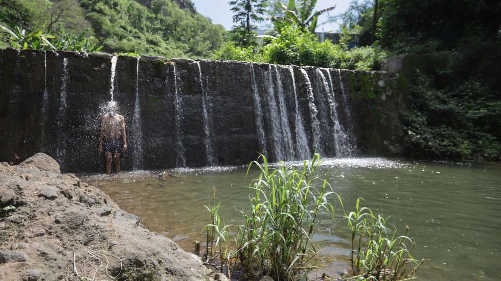 Anilton Fortes, 39 anos, desfruta do “luxo de ter uma cachoeira” enquanto se banha na Cachoeira Maravilha, localizada na zona de Picos, na Ilha de Santiago, em Cabo Verde, 11 de outubro de 2024. (ACOMPANHA TEXTO DE 14-10-2024) ELTON MONTEIRO/LUSA