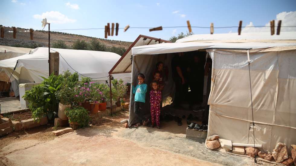 epa11659205 Displaced children stand inside a tent at a camp of Internally Displaced People (IDP) at Ma'arrat Misrin, Idlib, northwest Syria, 14 October 2024. Carden arrived in northwest Syria to inspect camps of displaced Syrians, the distribution of food aid provided by the WFP and meet with Syrians who fled the hostilities in Lebanon amid the conflict between Israel and Hezbollah. According to the UNHCR on 14 October, a total of approximately 276,000 people (both Lebanese and Syrians) are estimated to have crossed from Lebanon to Syria since the escalation of hostilities in Lebanon. At least 21,000 Syrians fleeing the conflict in Lebanon arrived at north-east Syria and around 3,000 have arrived in north-west Syria, UNHCR stated.  EPA/BILAL AL HAMMOUD