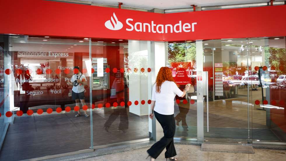 Uma mulher caminha em frente a uma sucursal do Banco Santander, em Lisboa, 12 de agosto de 2024. Banca. Santander. Economia. ANTÓNIO PEDRO SANTOS/LUSA