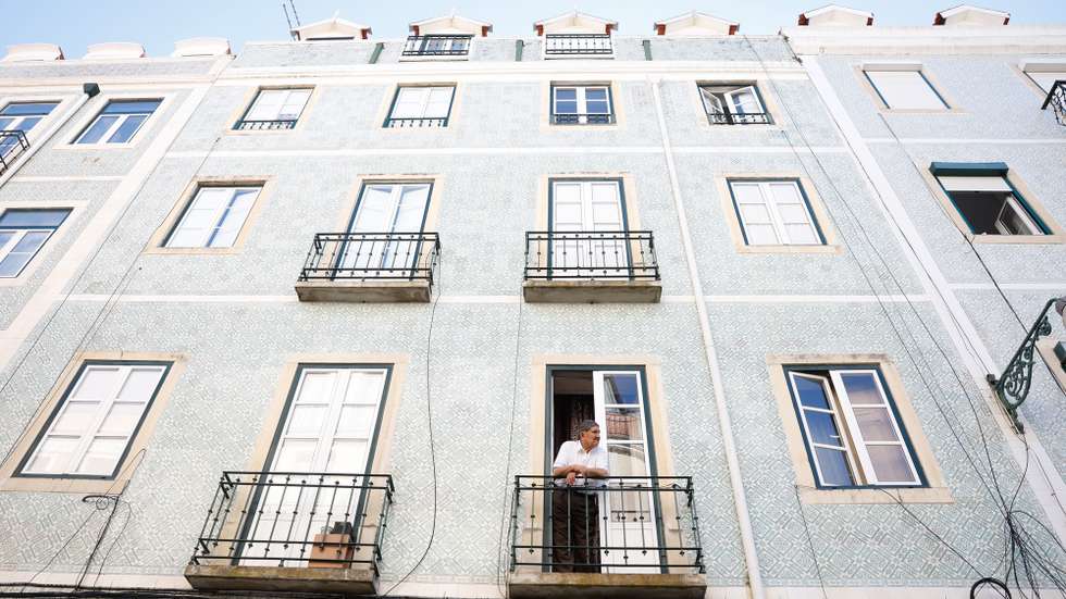 Um morador observa o movimento da rua da janela de sua casa, em Lisboa, 19 de agosto de 2024. Habitação. Rendas. Imobiliário. ANTÓNIO PEDRO SANTOS/LUSA