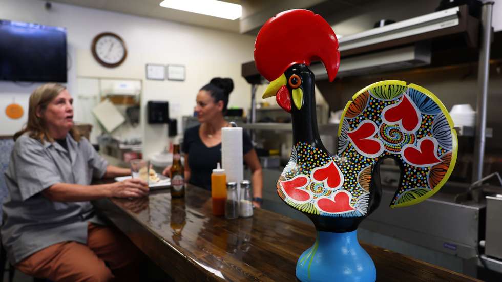 Um galo de Barcelos gigante é um dos 'amuletos' presentes no restaurante da luso-descendente Rosemary Pereira (C), proprietária do restaurante Little Portugal, instalado na pequena cidade de Fuquay-Varina, Carolina do Norte, Estados Unidos da América, 31 de outubro de 2024. Com pratos portugueses e venda de produtos nacionais, tem o negócio há quatro anos e é apoiante convicta de Donald Trump, principalmente por achar que a economia americana irá melhorar se o candidato republicano vencer as eleições. (ACOMPANHA TEXTO DE 02 DE NOVEMBRO DE 2024). NUNO VEIGA/LUSA