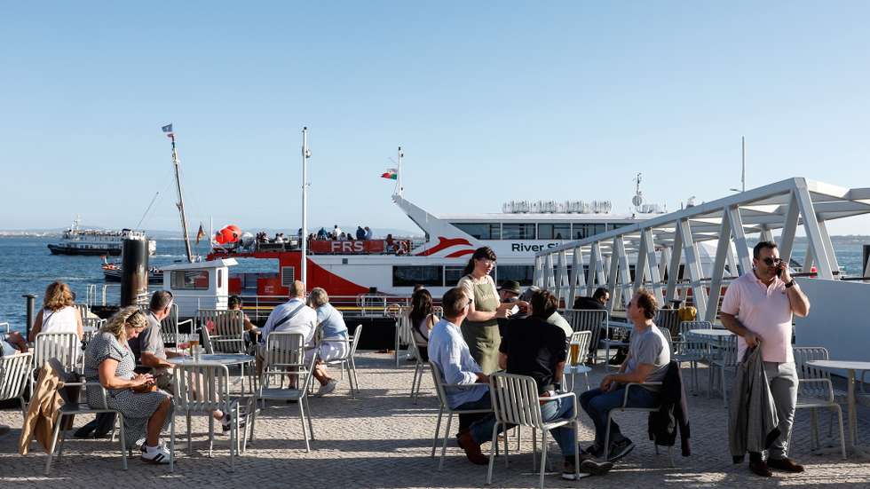 Turistas numa esplanada no Terreiro do Paço, em Lisboa, 10 de outubro de 2024. Cacilheiro. Esplanadas. Lazer. Rio Tejo. Turismo. ANTÓNIO PEDRO SANTOS/LUSA