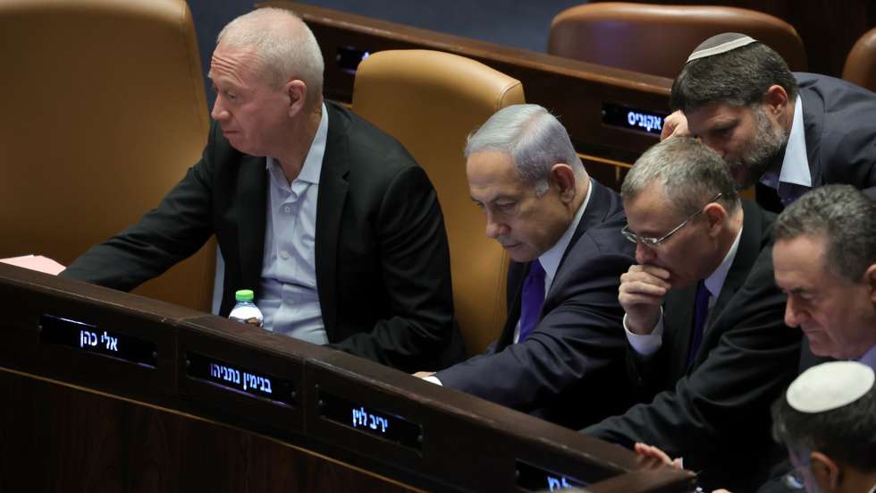 epaselect epa10765821 Israeli Prime Minister Benjamin Netanyahu (C), Minister of Defense Yoav Gallant (L) and Deputy Prime Minister and Minister of Justice Yariv Levin (3-L) vote on law on justice system reform at the Knesset, Israel, 24 July 2023. Mass protests continue across the country as the Israeli parliament, or Knesset, is set to hold a final vote on the bill that would limit the Supreme Court's powers.  EPA/ABIR SULTAN
