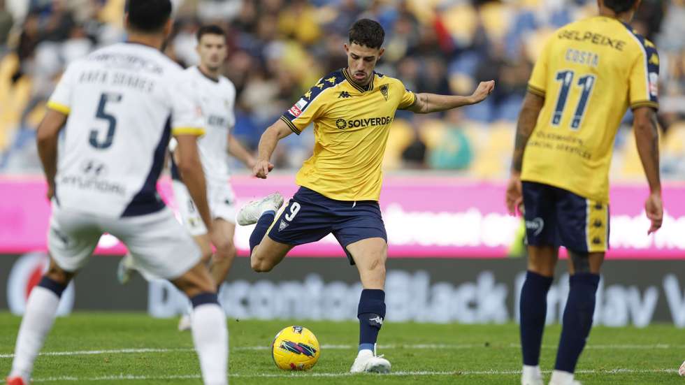 O jogador do Estoril Praia, Marquês (C), disputa a bola com o jogador do Famalicão, Rafa Soares (E), durante o jogo da I Liga de futebol, realizado no Estádio António Coimbra da Mota, Estoril, Cascais, 01 de dezembro de 2024. ANTÓNIO PEDRO SANTOS/LUSA