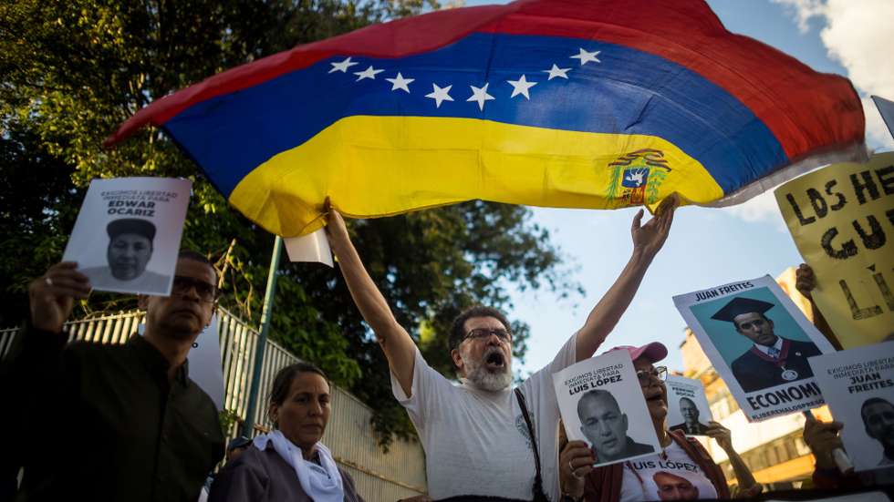 epa11744786 A man holds a Venezuelan flag during a demonstration demanding freedom for political prisoners in Caracas, Venezuela, 27 November 2024. A group of relatives of those considered 'political prisoners' in Venezuela protested in Caracas to demand their 'immediate' release, as well as a 'dignified treatment' for these people detained 'unjustly,' the great majority after the presidential elections last 28 July.  EPA/MIGUEL GUTIERREZ
